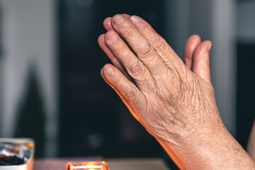 Hands of an old woman folded for prayer.