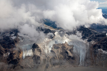 Panoramic aerial view of the Alaskan Range and its glaciers through the clouds 
