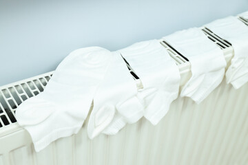 White socks drying on a radiator indoor