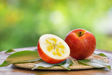 Red Kotoku Apple in the basket over green natural Blur background, Fresh Red Honey core Apple on bamboo mat.  .