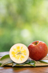 Red Kotoku Apple in the basket over green natural Blur background, Fresh Red Honey core Apple on bamboo mat.  . © MERCURY studio