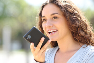 Woman smiling while is dictating message on phone