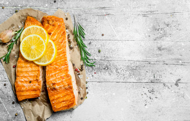 Grilled salmon fillet with slices of fresh lemon. - 561733345