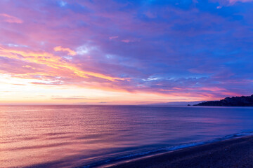 view at sunrise or sunset in sea with nice beach , surf , calm water and beautiful clouds on a background of a sea landscape