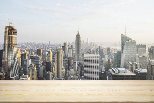 Blank table top made of wooden planks with beautiful New York cityscape at daytime on background, mockup