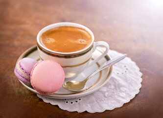 cup of coffee and macarons on a wooden background