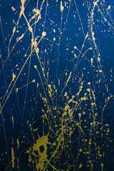 Abstract yellow paint splashes, element of creative graffiti on a bright blue background.