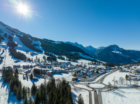 Germany, Bavaria, Oberjoch, Sun shining over snow-covered village in Allgau Alps
