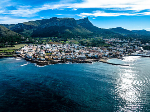 Aerial view of mountain ranges with town and sea under blue sky, Colonia de Sant Pere, Arta, Majorca, Spain