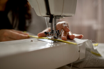 Woman using sewing machine at home