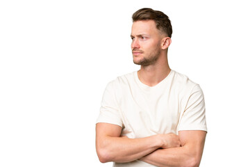 Young blonde caucasian man over isolated background looking to the side