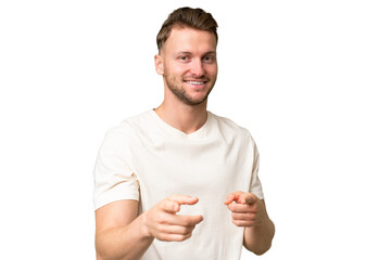 Young blonde caucasian man over isolated background surprised and pointing front