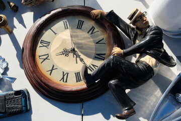 A flea market in Valencia on a sunny day. A very beautiful vintage watch with a man's figure in a suit