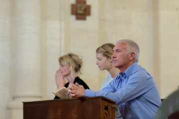sad people praying in church