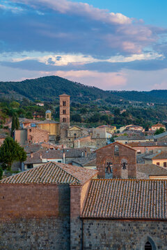 Italy, Lazio, Bolsena,Italy, Lazio, Bolsena, Old town houses with bell tower and forested hill in background