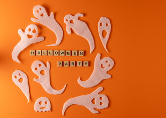 White ghosts craft for Halloween party. Wrapping paper ghost on orange background top view. Cartoon creepy Whisper. DIY hand made. Set boo characters. Word wooden letter phrase.