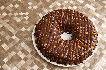 chocolate donut on a platter on a golden tablecloth