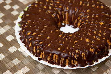 chocolate donut on a platter on a golden tablecloth