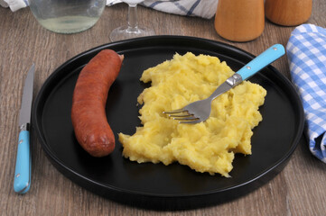 Assiette de purée de pommes de terre au beurre avec une saucisse fumée