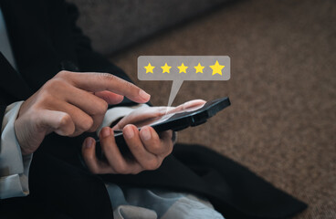 Customer review, satisfaction, feedback, survey concepts. The User giving 5 stars point rating to service experience, business ranking on mobile smart mobile phone in businesswoman's hands.