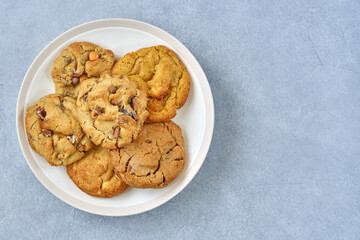 Assorted cookies with dark and white chocolate in a plate. Top view