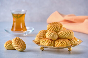 Traditional arabic semolina maamoul or mamoul cookies with dates , walnuts and pistachio nuts . Closeup