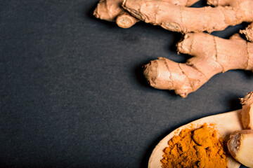 Cup of spiced tea with cinnamon sticks, lemon and jinger on rustic table.