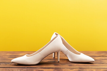 Obraz premium beige shoes on wooden floor on yellow background