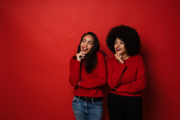 Two young african american women smiling and looking aside at copyspace