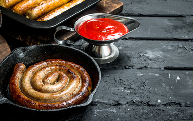 Fried sausages with tomato sauce.