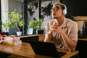 African business man using laptop while sitting in modern office kitchen