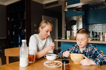 Mom and son eating breakfast at home