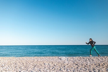 running on the sand, a woman runs along the beach
