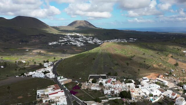 Spain, Lanzarote, Canary - Drone aerial view of Maria village with white houses , palms and volcano by the sea ocean - headquarters of the Cesar Manrique Museum - travel in north Lanzarote island 