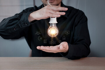 Businessman touching a bright light bulb. Concept of Ideas for presenting new ideas Great inspiration and innovation new beginning.
