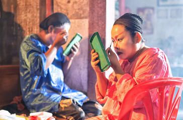 Chinese opera actor cosmetic make up painting face face before perform at back stage of theater