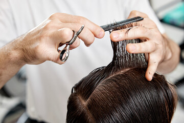 Obraz premium Barber talking to caucasian man while sitting in chair