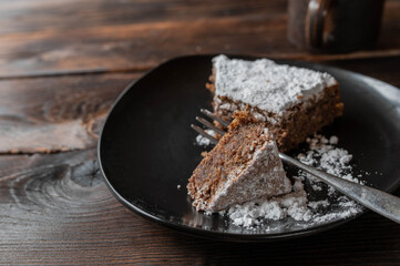 Slice of chocolate cake on a brown plate. Traditional italian torta caprese