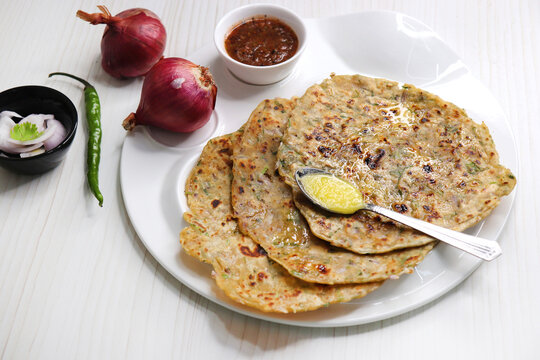 Indian traditional Hot Onion Paratha with tomato chutney. Indian onion stuffed Flatbread. also known as Pyaz ke parathe in Hindi. over a light background with copy space.