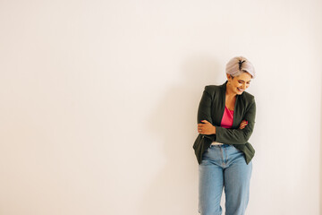 Successful businesswoman smiling happily against an office wall