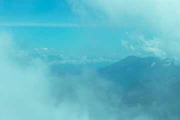 Bright panorama of the cloudy Andes Mountains with a blue sky from the Cerro las Nubes (Mount of the Clouds) in Jerico, Antioquia, Colombia. Very pale white and blue sky.