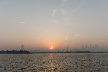 The view from Palm Jumeirah Beach to the city limits. Bright sunrise, sunshine in the frame. 