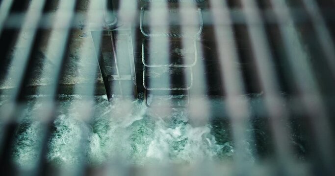 Rushing Flood Water in Sewer Drainage Overflow Tunnel through Metal Grate. Underground Storm Infrastructure Heavy Rain Ladder 4k
