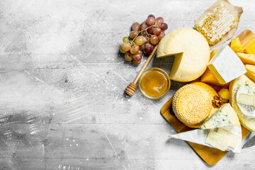Fototapeta na wymiar Different kinds of cheese with honey and grapes.