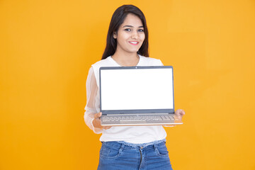 Beautiful indian girl showing laptop with white empty display screen to put advertisement isolated...