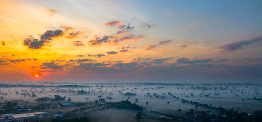 Obraz premium Panorama Top view Aerial photo from flying drone over rural village in Thailand.Top view beautiful Sunset.Sunrise with foggy on field background.