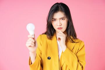 Image of young Asian businesswoman holding light bulb, brainstorm concept