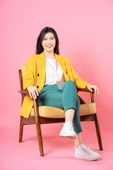 Image of young Asian businesswoman sitting on chair
