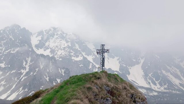 Metal crucifix built on the top of the mountain. attached to the cross are Tibetan flags. pan camera movement