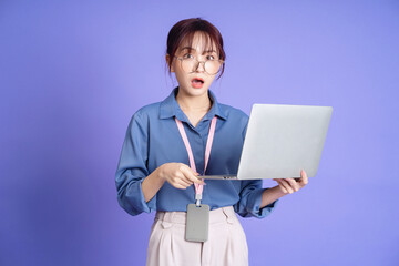 Photo of young Asian businesswoman holding laptop on background